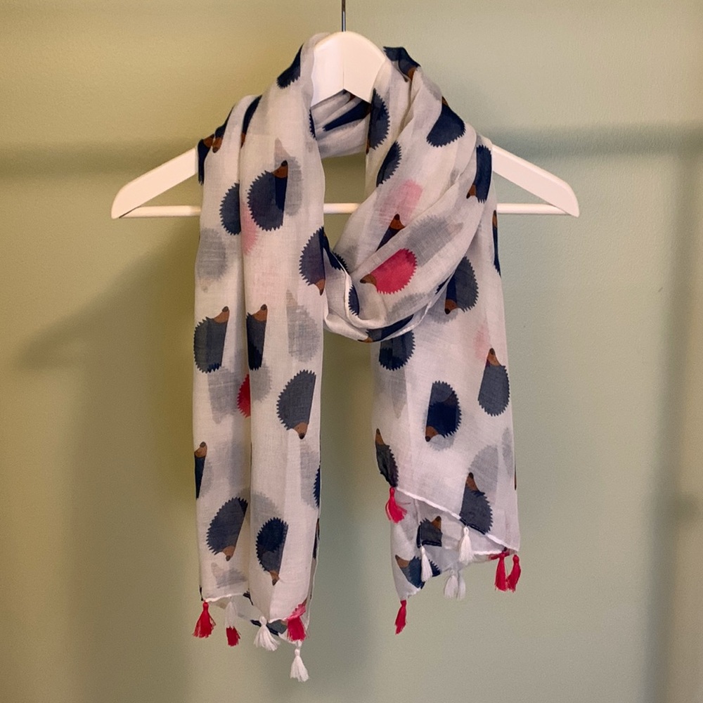 White scarf with navy and pink hedgehog print.